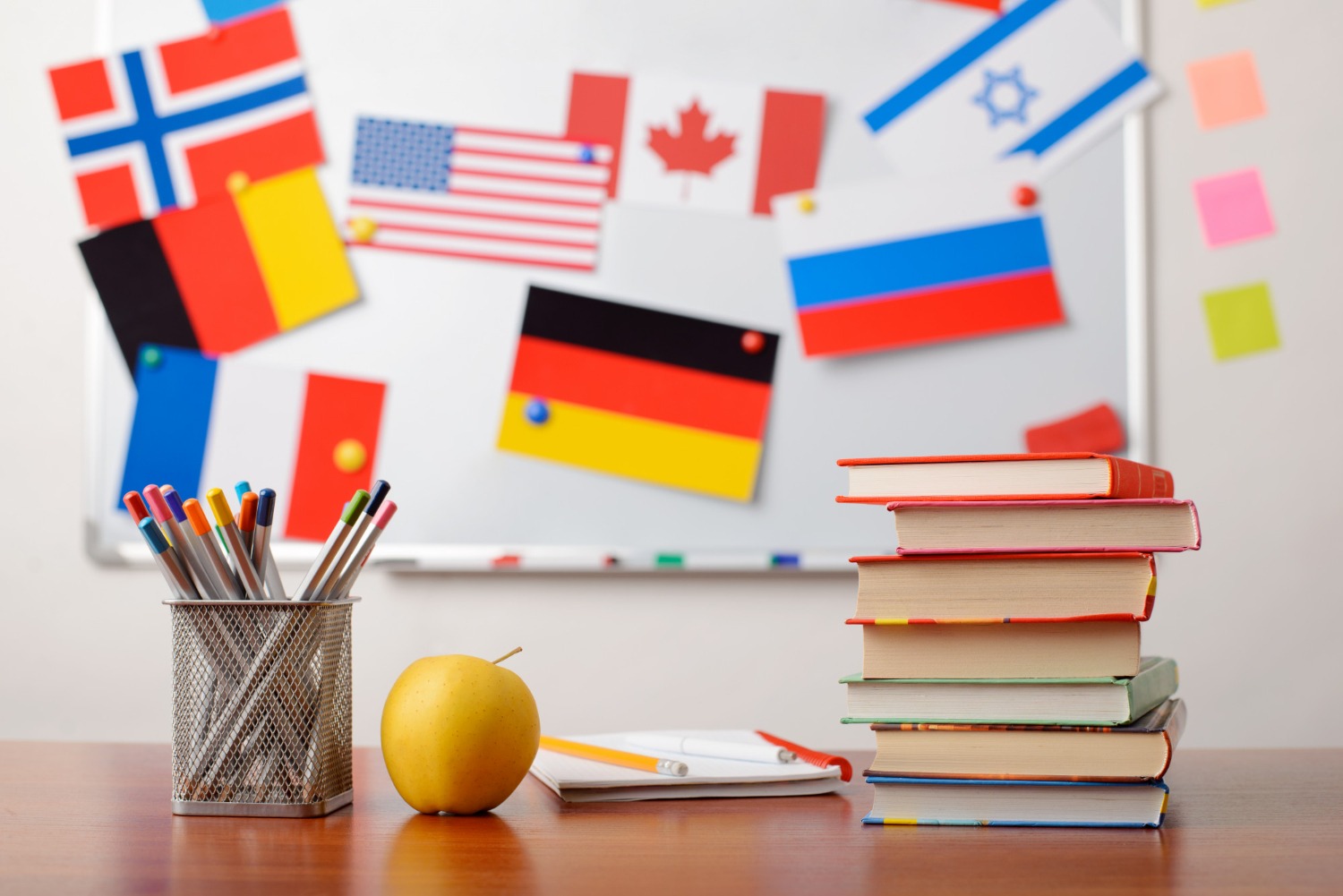 stack-books-front-school-whiteboard-with-flags-different-countries (1)